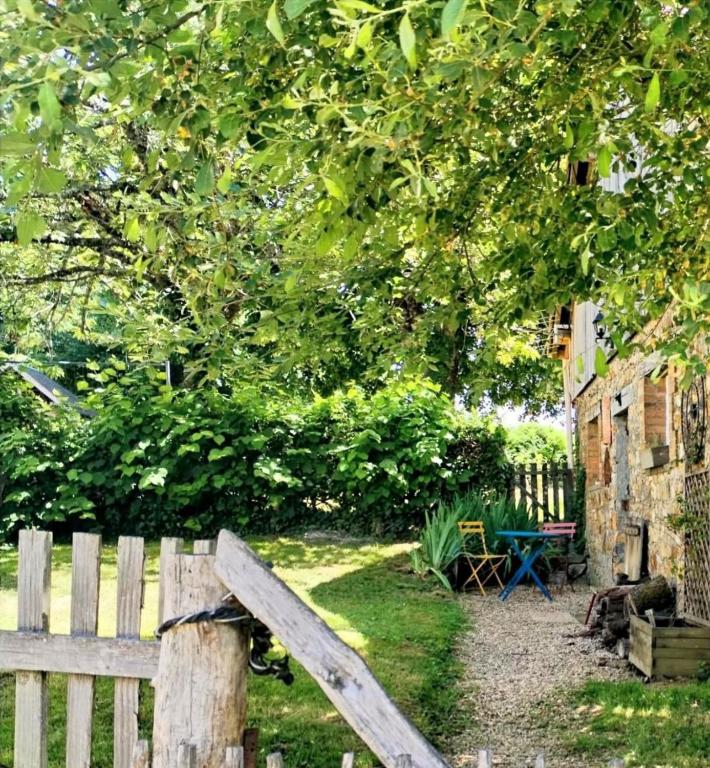 a wooden fence in a yard with a tree at Limousin, Saint Vitte sur Briance Vacances au Mazet de Nova in Martageix