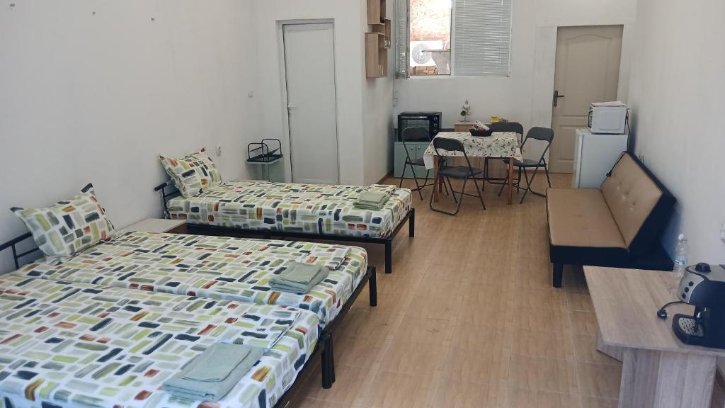 a room with two beds and a table in it at Studio Miguel in Veliko Tŭrnovo