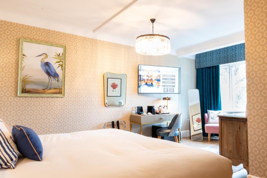 a hotel room with a bed and a desk and a chair at Queens Hotel & Spa Bournemouth in Bournemouth