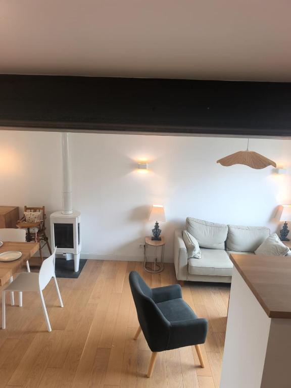 a living room with a couch and a table at Maison près de la plage in Sangatte