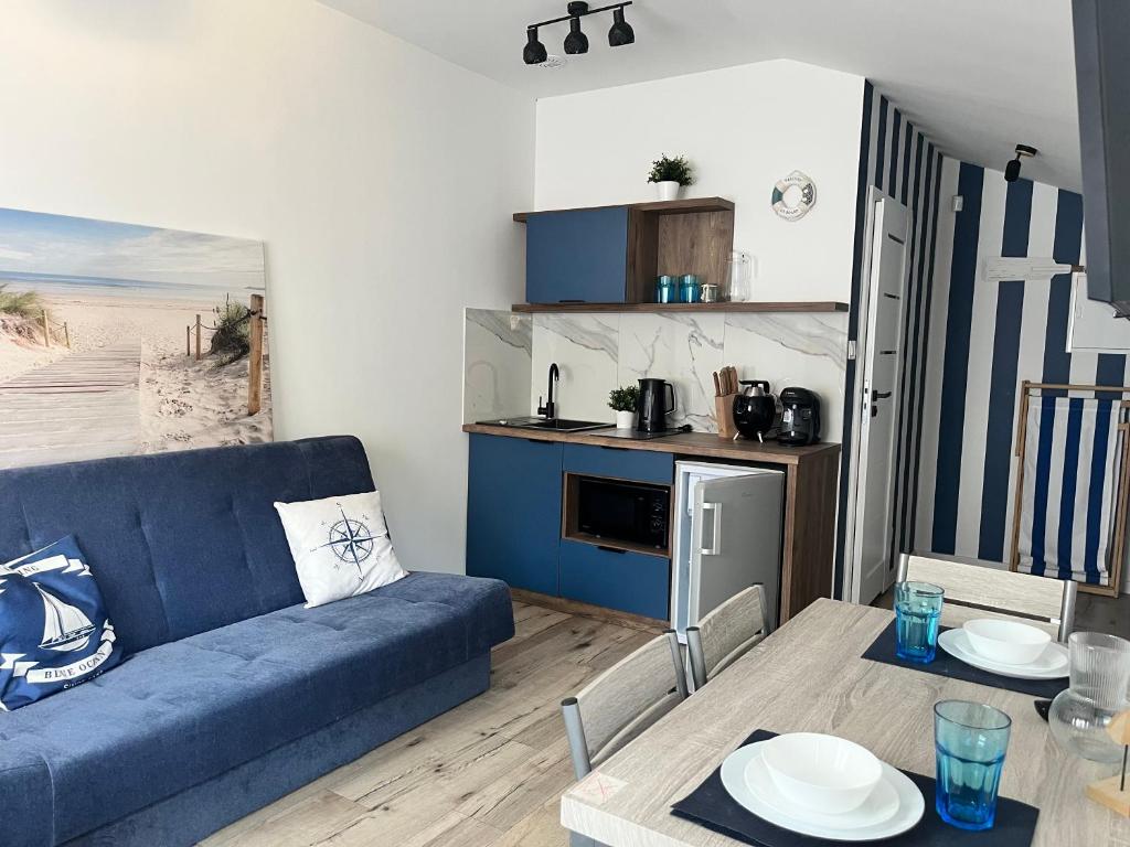 a living room with a blue couch and a table at Blue Apartment B Dębina - prywatny taras na dachu , 400 m od morza, in Debina