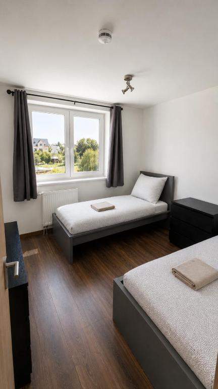 a room with two beds and a window at Monteurwohnungen in Markranstädt in Markranstädt