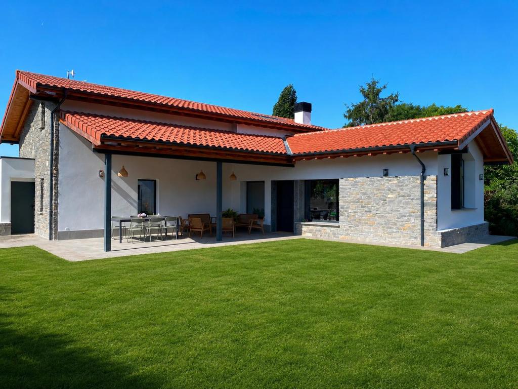 a house with a green lawn in front of it at La Llarena in La Isla