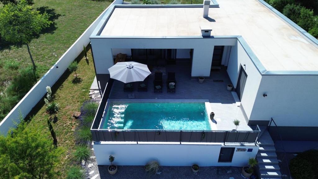 an overhead view of a house with a swimming pool and an umbrella at Traumhafte Villa Dubi bei Labin in Labin
