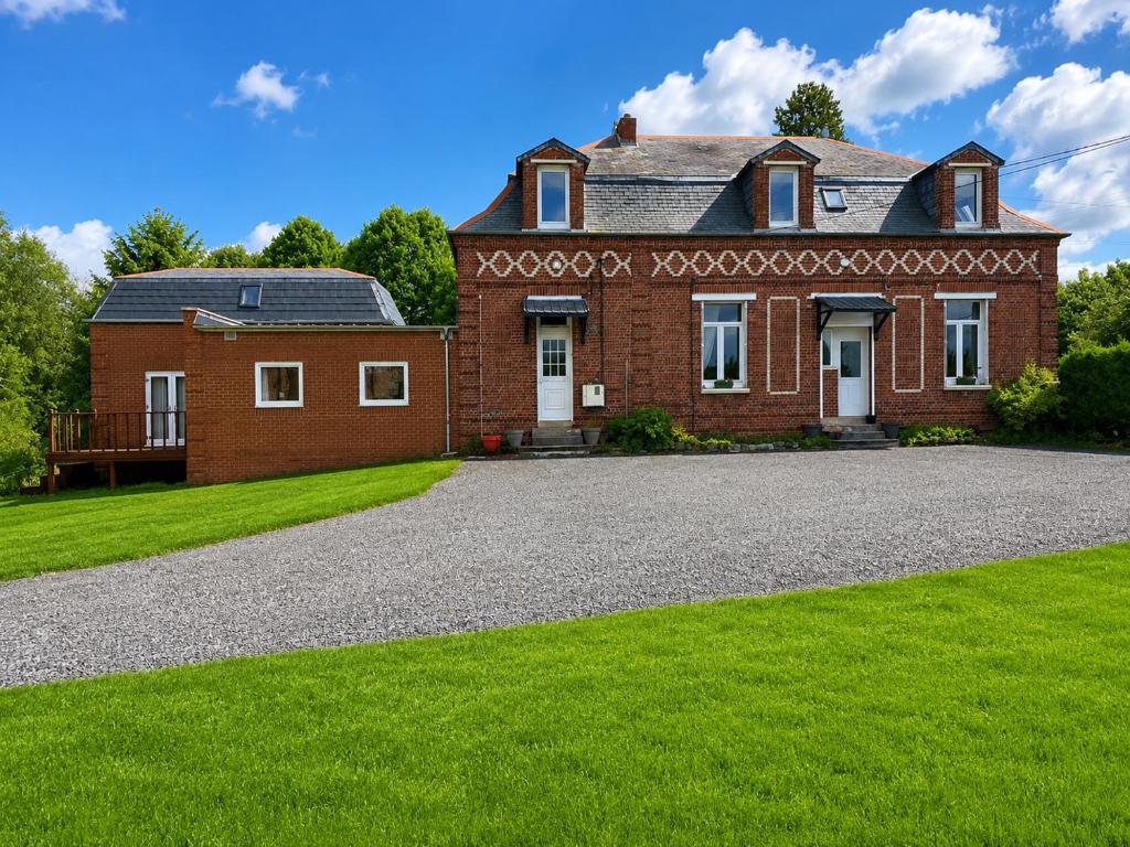 a large brick house with a gravel driveway at La Ferme des Coquelicots in Miraumont