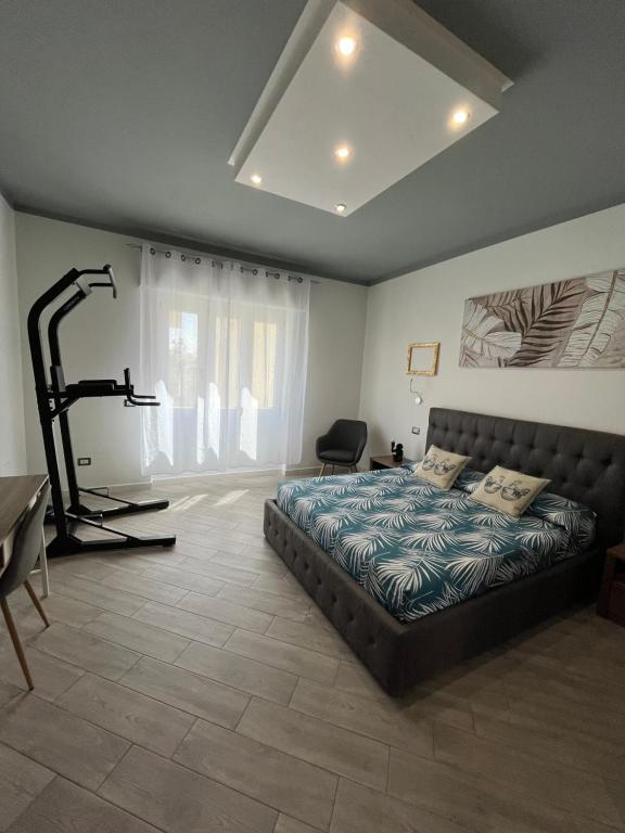 a bedroom with a bed and a treadmill at La Base Fitness House in Decimomannu