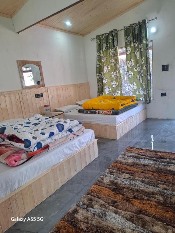 two beds in a room with two rugs at Auli haven in Joshīmath