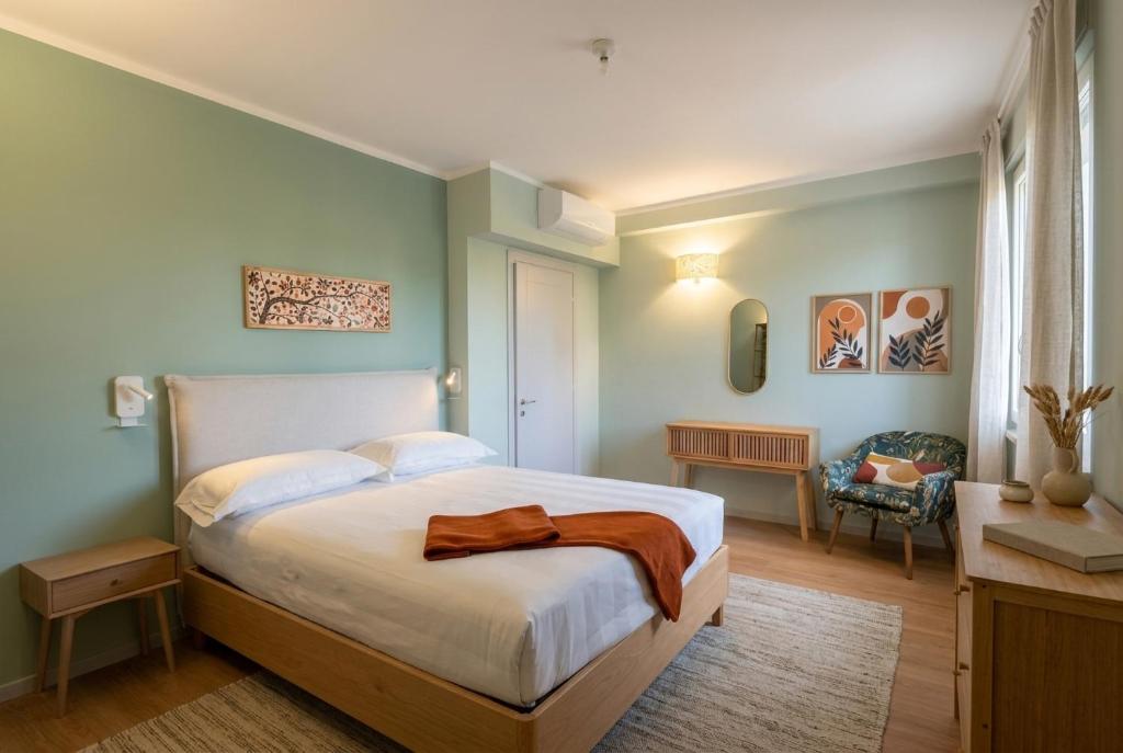 a bedroom with a large bed and a chair at My Tuscany Green Apartment in San Quirico dʼOrcia