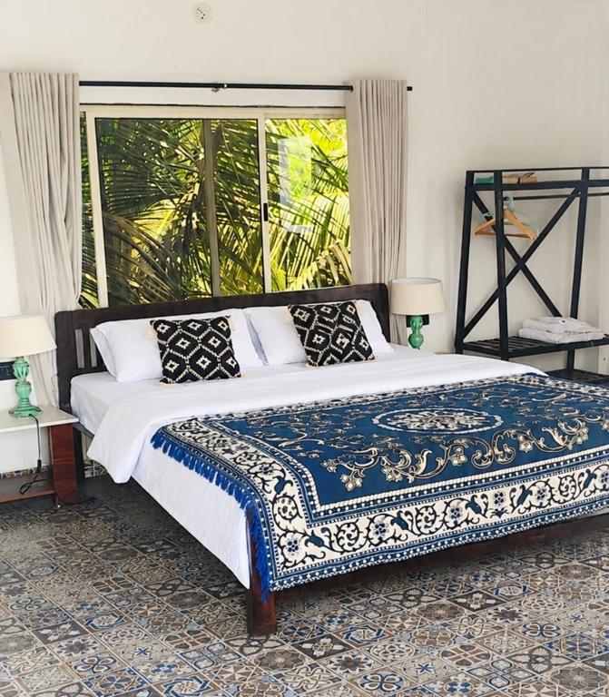 a bedroom with a bed and a large window at Bhumika by evaddo stays in Mandrem