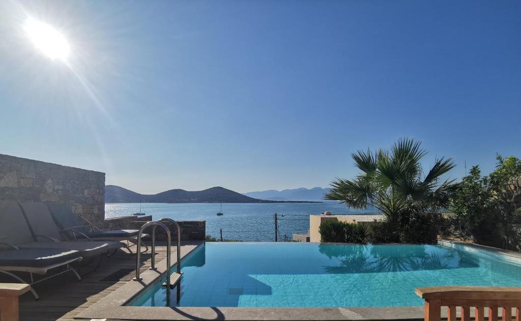 a swimming pool with a view of the water at Andromeda Sea View Villa in Epáno Eloúnda