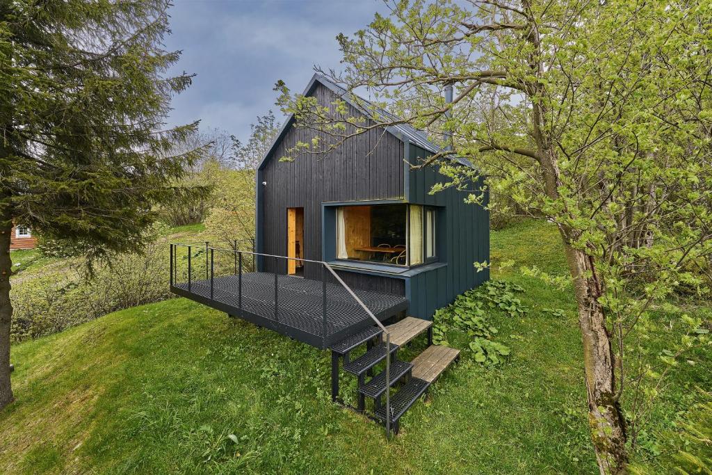 a small black house on a hill with stairs at Glamping KOLBENKA in Horní Malá Úpa