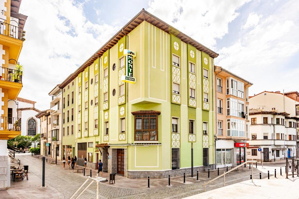 a yellow and green building on a street at Pension Monteverde in Cangas de Onís