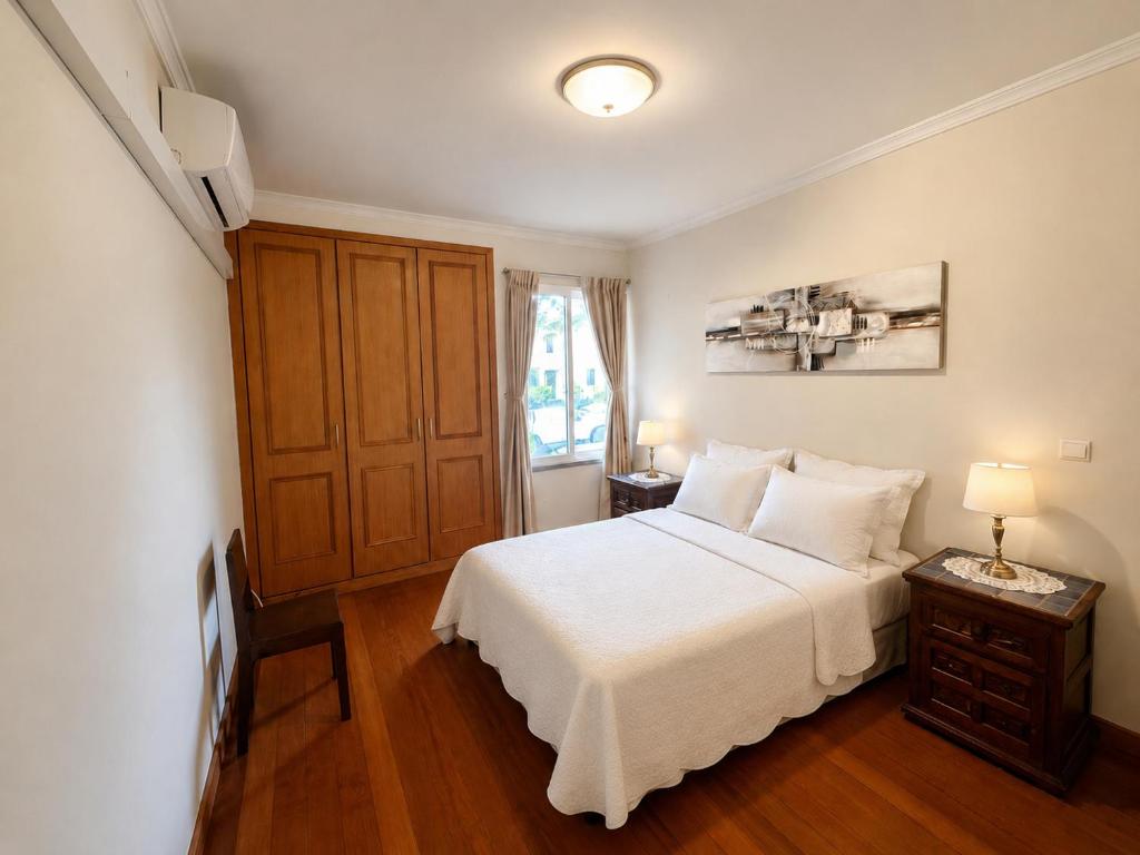 a bedroom with a white bed and a window at Cantinho de Santa Teresa in Canhas