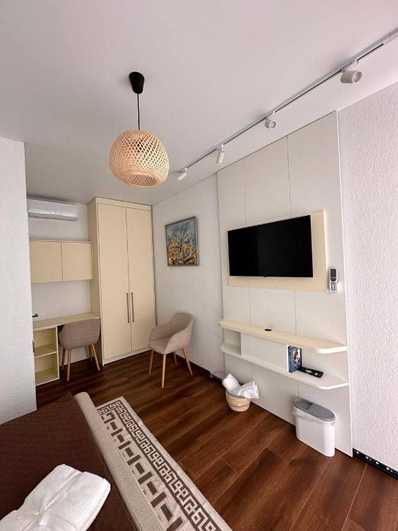 a living room with a flat screen tv and a couch at Vatra Dumeniului in Vorniceni