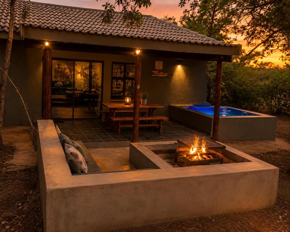 a backyard with a fire pit and a pool at Maningwe in Marloth Park