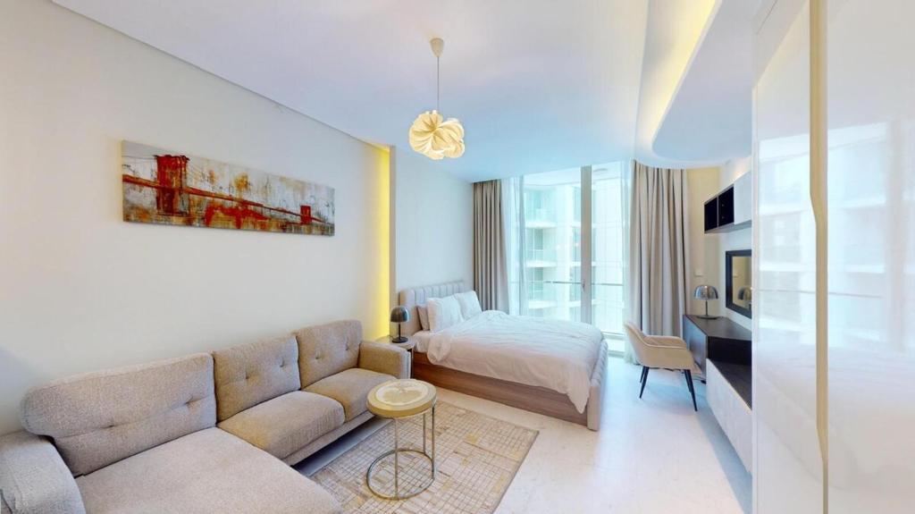 a living room with a couch and a bed at Bahrain Bay Retreat Studio in Manama
