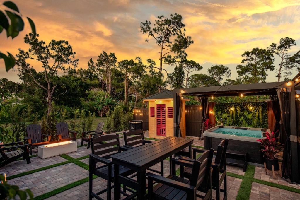 a house with a picnic table and a swimming pool at Black Vanilla Luxe Retreat - Sauna, Cold Plunge & Pure Relaxation in Naples