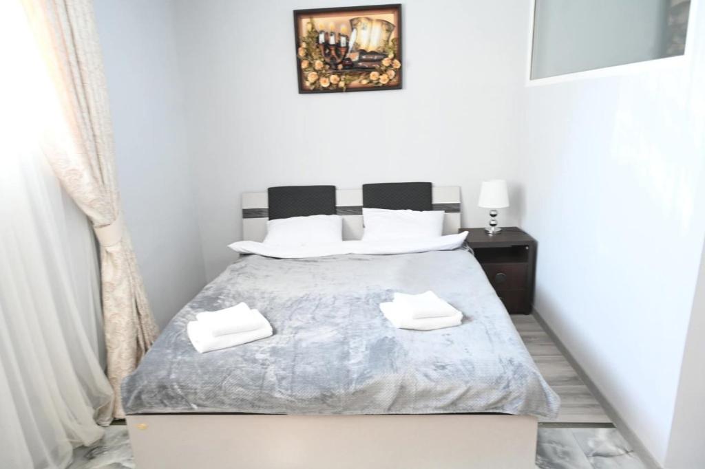 a white bedroom with a bed with white pillows at Oasis in Edineţ
