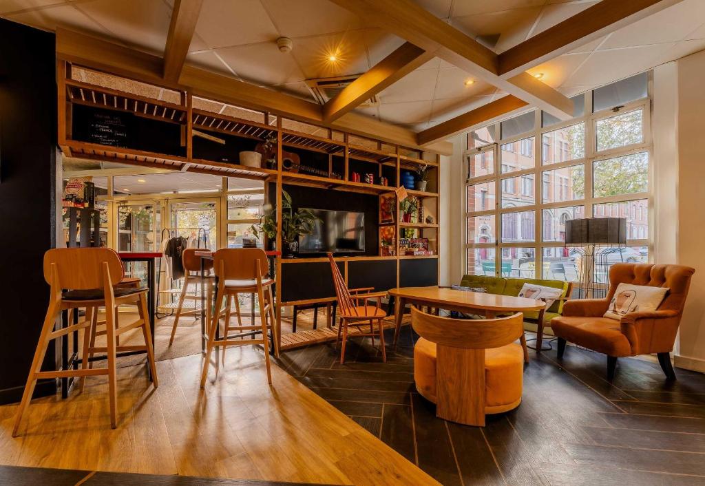 a bar with chairs and tables and a tv at B&B HOTEL Lille Roubaix Centre Grand-Place in Roubaix