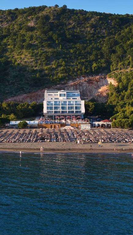 a large building on a beach next to the water at Prince Adriatic Resort in Shëngjin