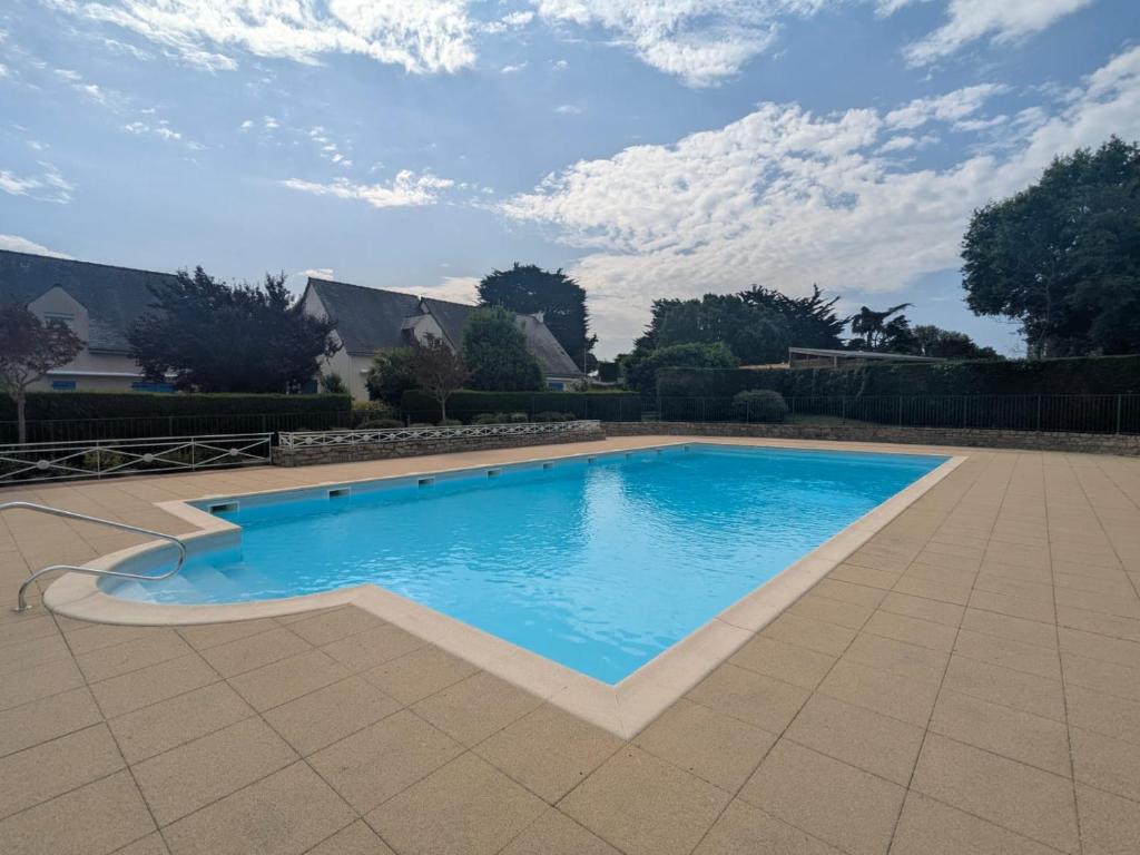 a large swimming pool in a yard with a house at Maisonnette Piriac-sur-Mer in Piriac-sur-Mer