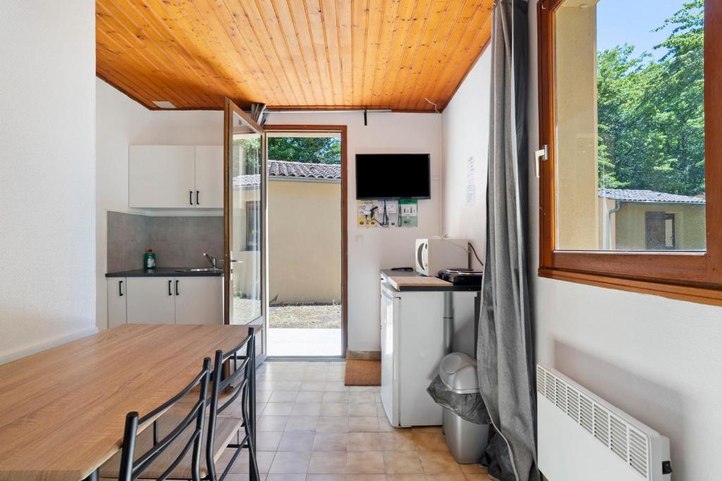 a kitchen and dining room with a table and a window at 16. Les Sources option clim- 2 pers in Calviac