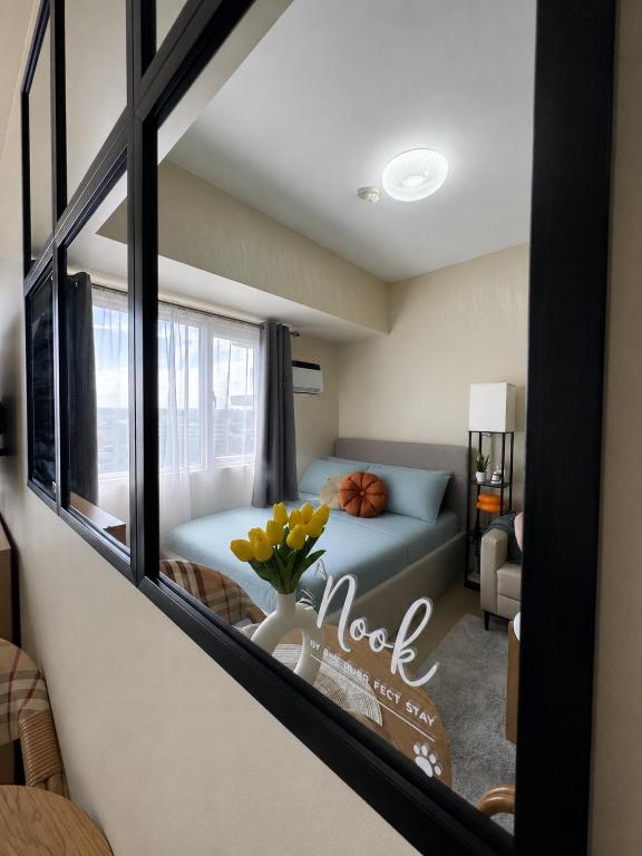 a room with a bed and a window with yellow flowers at The Nook at Avida Towers 2 CDO in Cagayan de Oro