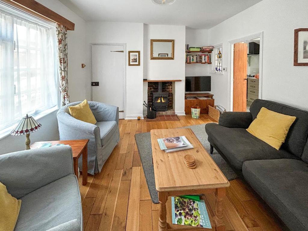 a living room with two couches and a coffee table at Flint Cottage in Saxmundham