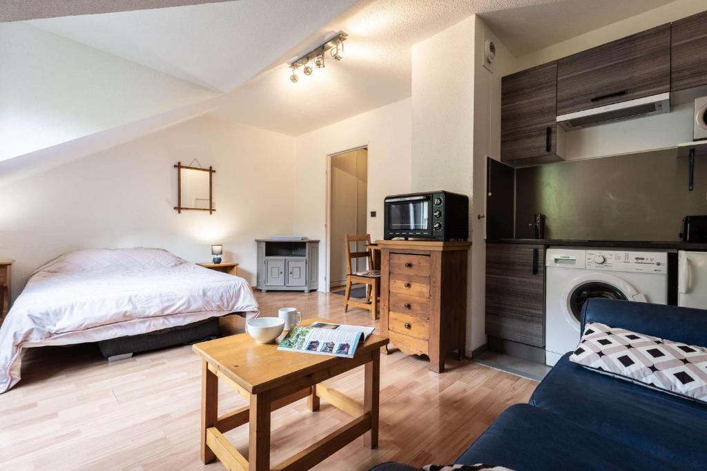 a bedroom with a bed and a tv and a table at Studio 766 – LA TARENTAISE in Brides-les-Bains
