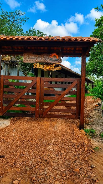 a wooden fence with a sign on it at Chalé Canto do Rio in Santo Amaro