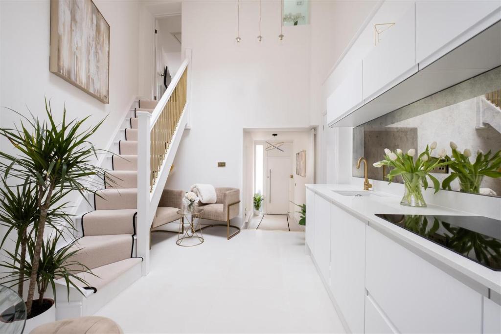 a white living room with stairs and plants at Beeches Retreat in Shrewsbury