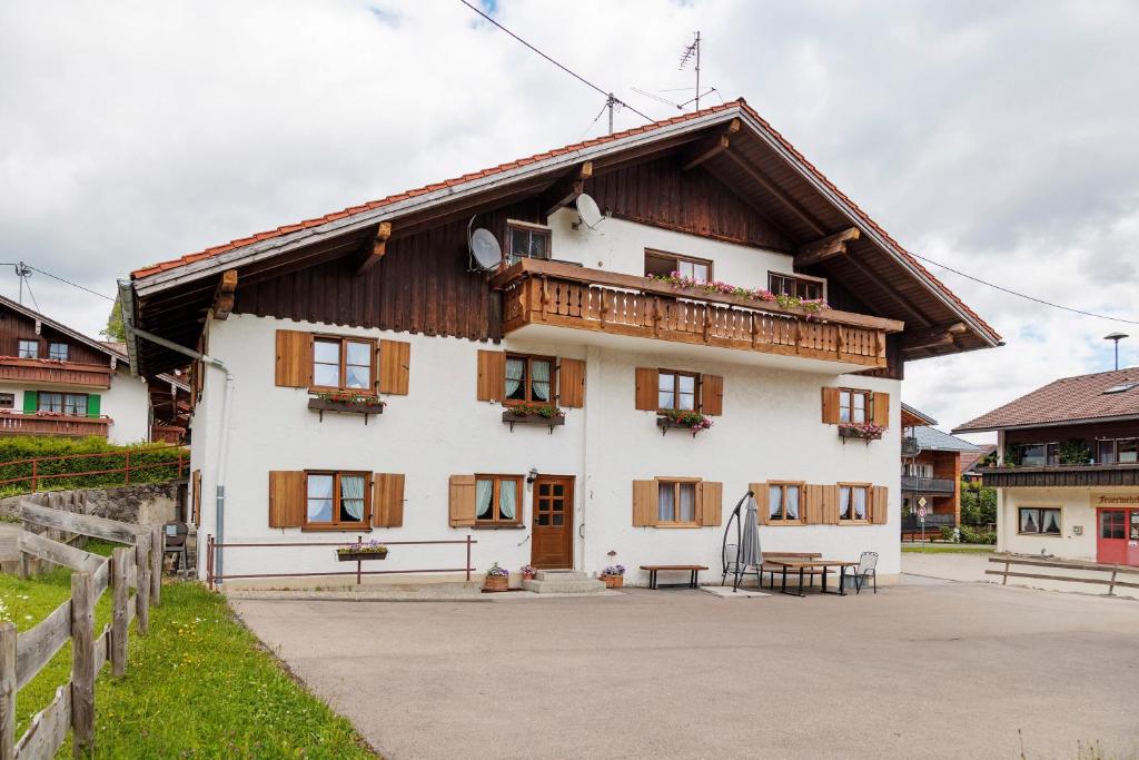 a large white house with a wooden roof at Ferienwohnung Schaule in Bolsterlang