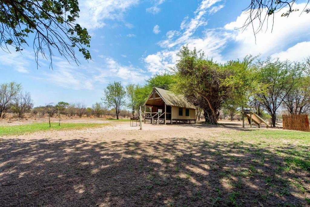 a small building with a playground in a field at Chobe River Campsite in Ngoma