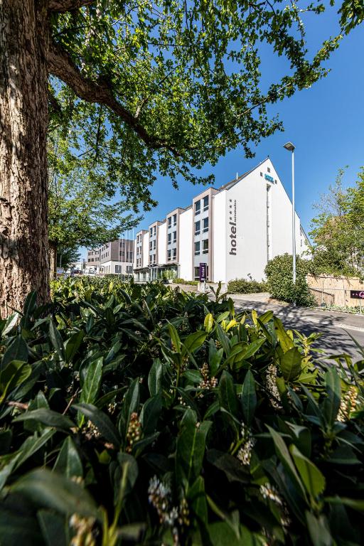 ein Gebäude mit einem Baum davor in der Unterkunft Hotel Münchwilen in Wil