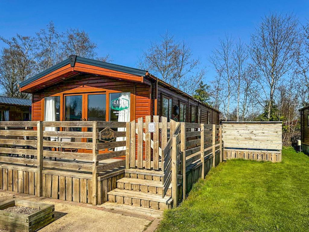 a small wooden cabin with a wooden fence at Aquila - Uk49467 in Morpeth