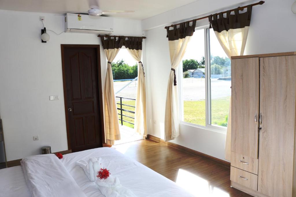 ein Schlafzimmer mit einem Bett und einem großen Fenster in der Unterkunft Acqua Blu Rasdhoo in Rasdu