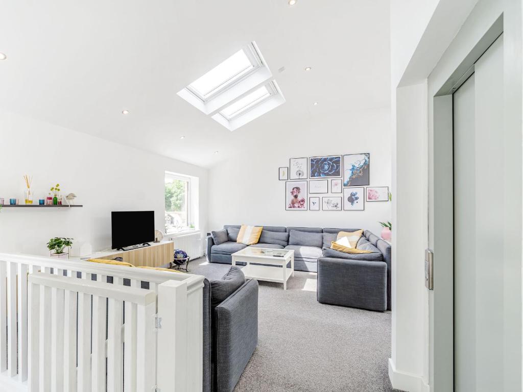 a living room with a couch and a tv at High Trees View in Knaresborough