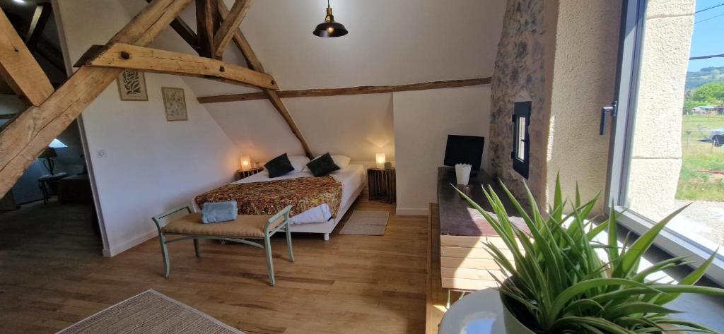a bedroom with a bed and a chair in a room at Les chambres de Mona in Tauriac