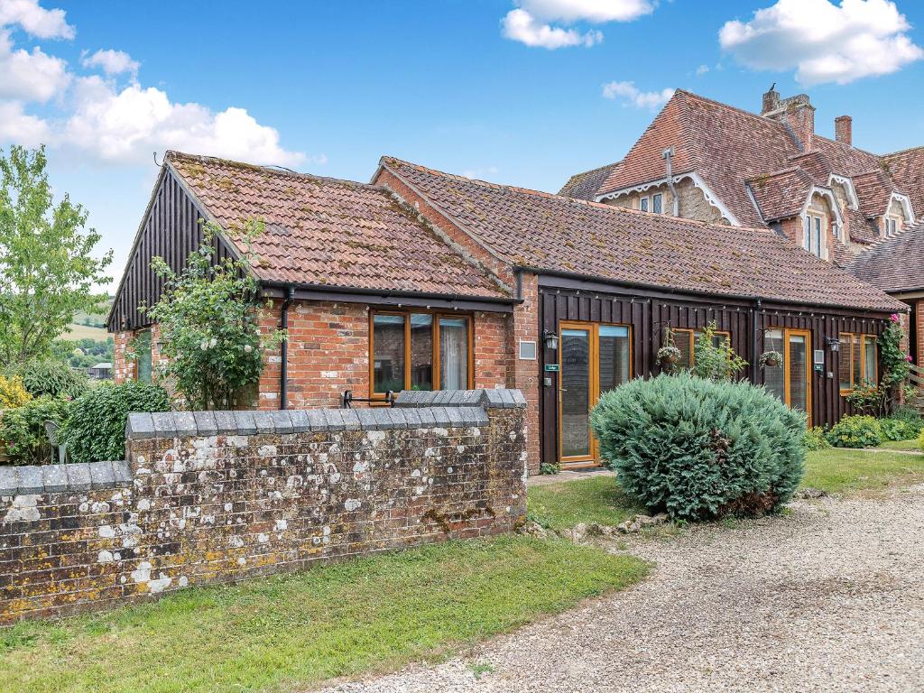 an old brick house with a stone wall at Lodge - Uk49989 in Blandford Forum