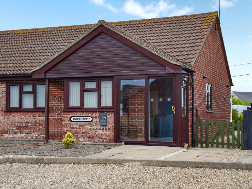 a red brick house with a large glass door at Turnstones in Walcott