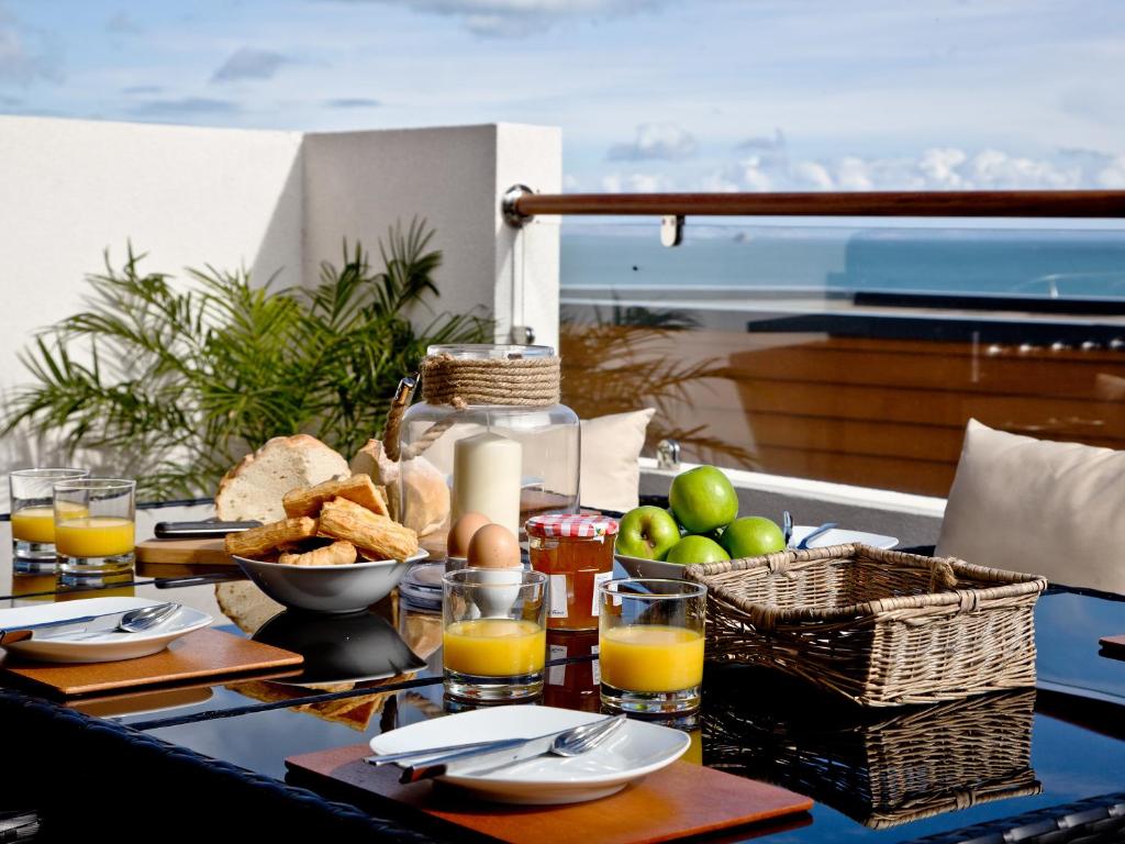 a table with food and drinks and baskets of fruit at Dunlin 1 - The Cove in Brixham