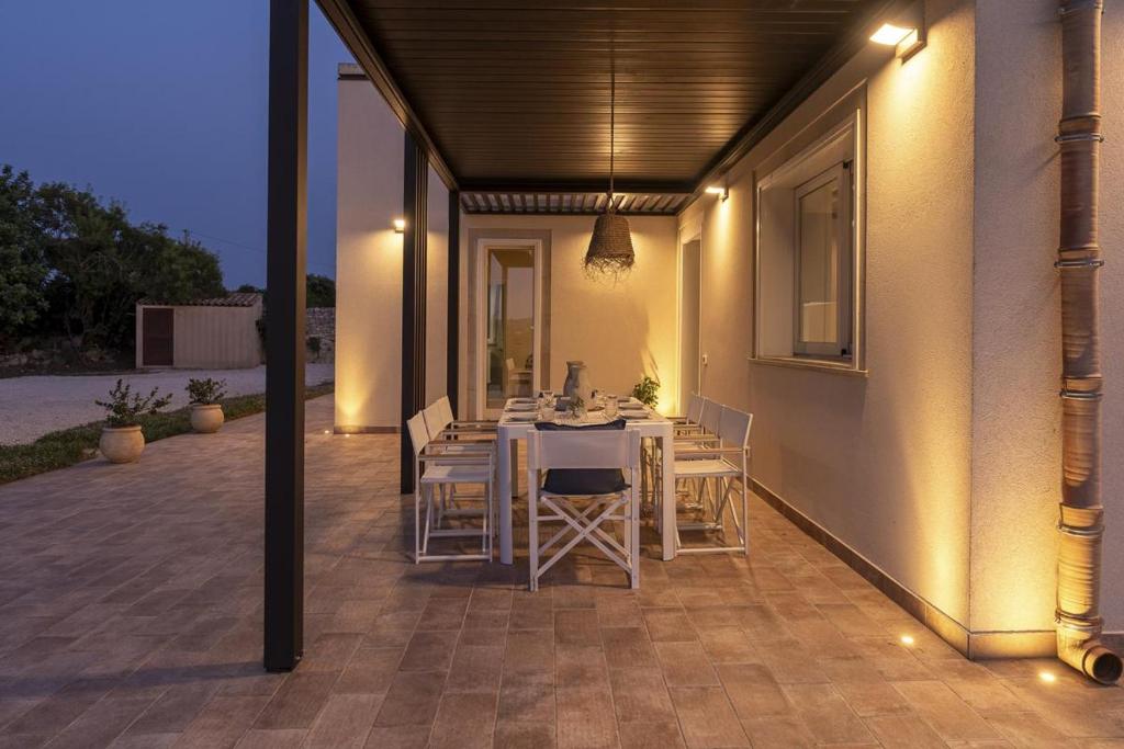 a dining area with a table and chairs on a patio at Villa Lumiere in Modica