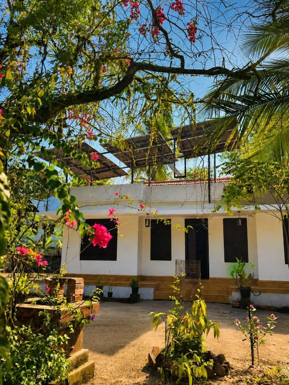 a building with windows and flowers in front of it at Nature Heritage by Marari in Mararikulam