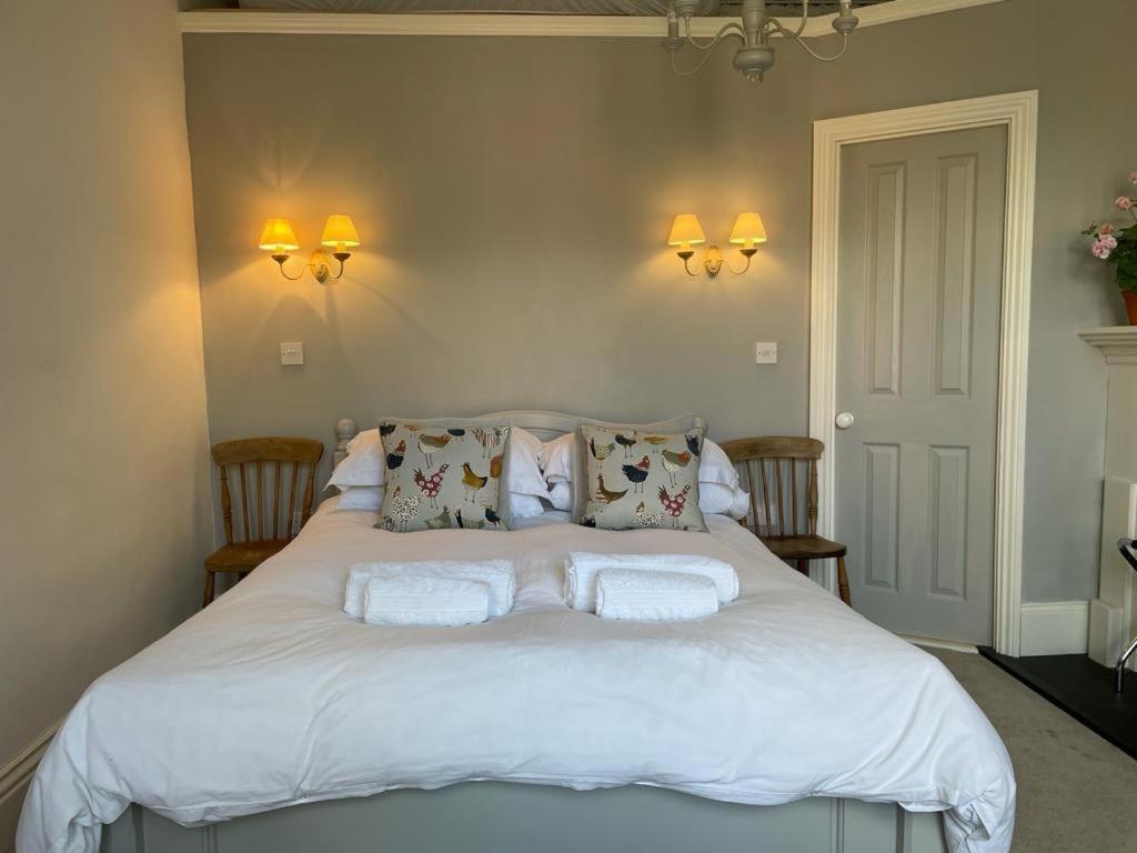 a bedroom with a white bed with towels on it at Poplars Farm in Henlow