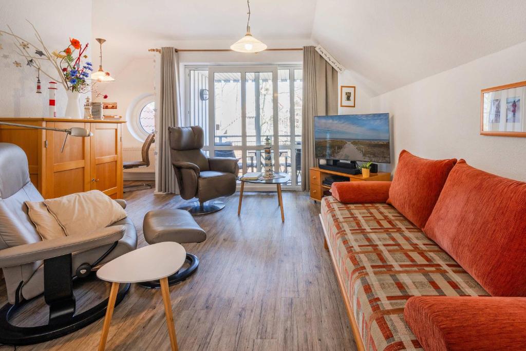 a living room with a couch and a tv at Seeblick Leuchtturm in Koserow