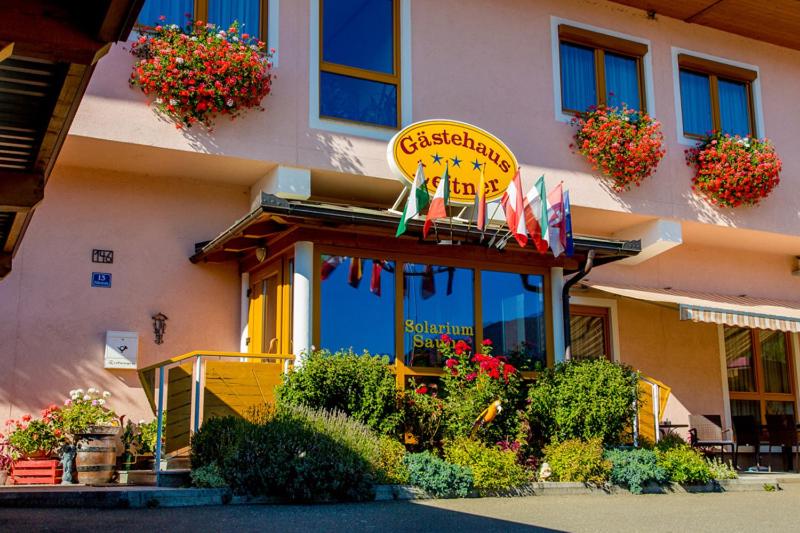 a restaurant with a sign on the side of a building at Leitner Gästehaus in Scheifling