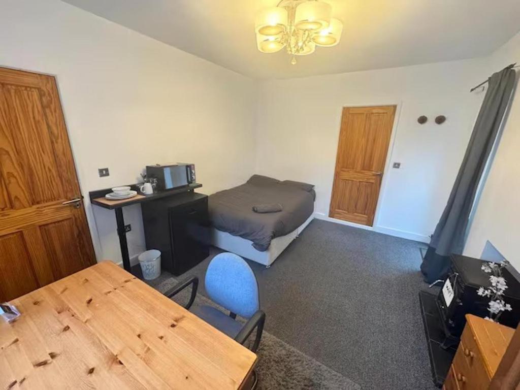 a room with a bed and a desk and a table at Studio sleeps 2 with Parking in Derby