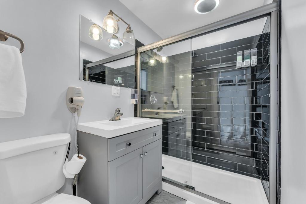 a bathroom with a shower and a toilet and a sink at Stay with Jay - Quarta Suite in Cleveland