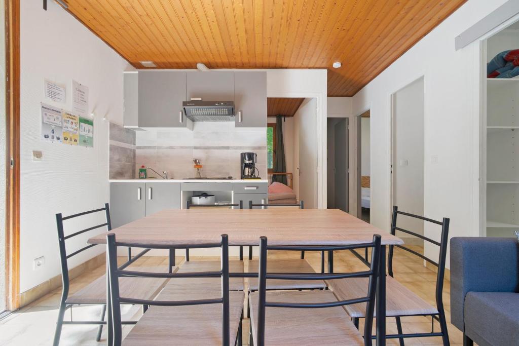 a dining room with a wooden table and chairs at 17.Les Etoiles option Clim- 7 pers in Calviac