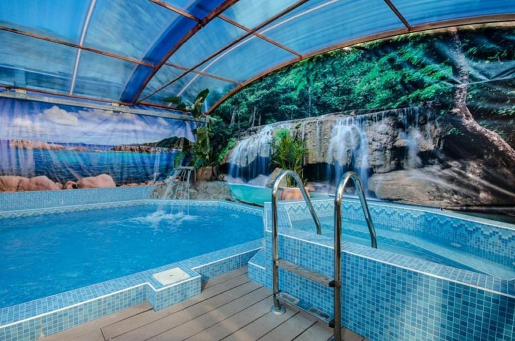 a swimming pool with a waterfall in a building at Bektza Ateva in Safed